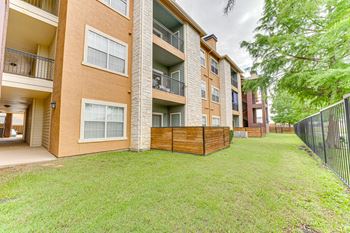 Ground floor patio with wooden privacy fence and lawn area
